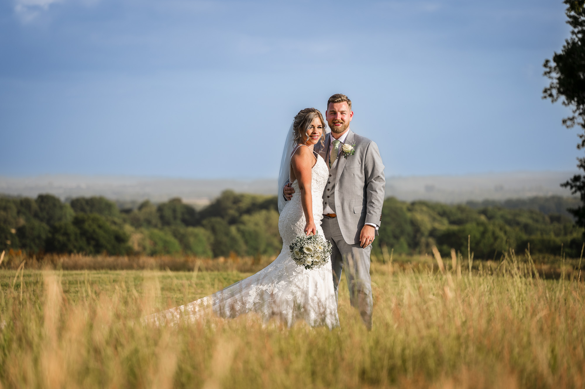 Bride and groom portrait in the meadow at Swallows Oast. Ticehurst, East Sussex | Oakhouse Photography