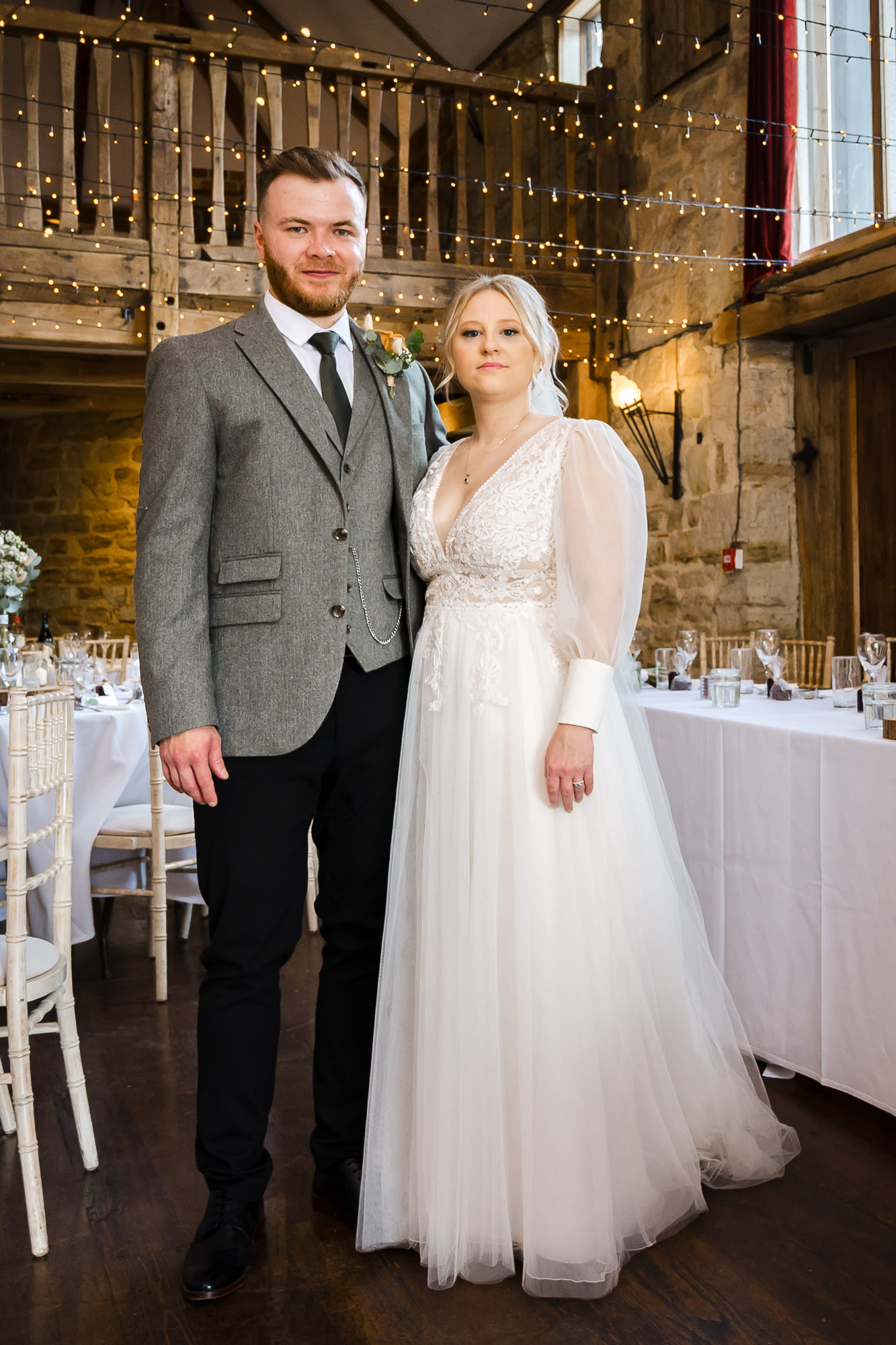 Portrait shot of bride and groom inside The Barn at Swallows Oast wedding venue, Ticehurst, East Sussex before the start of the wedding reception