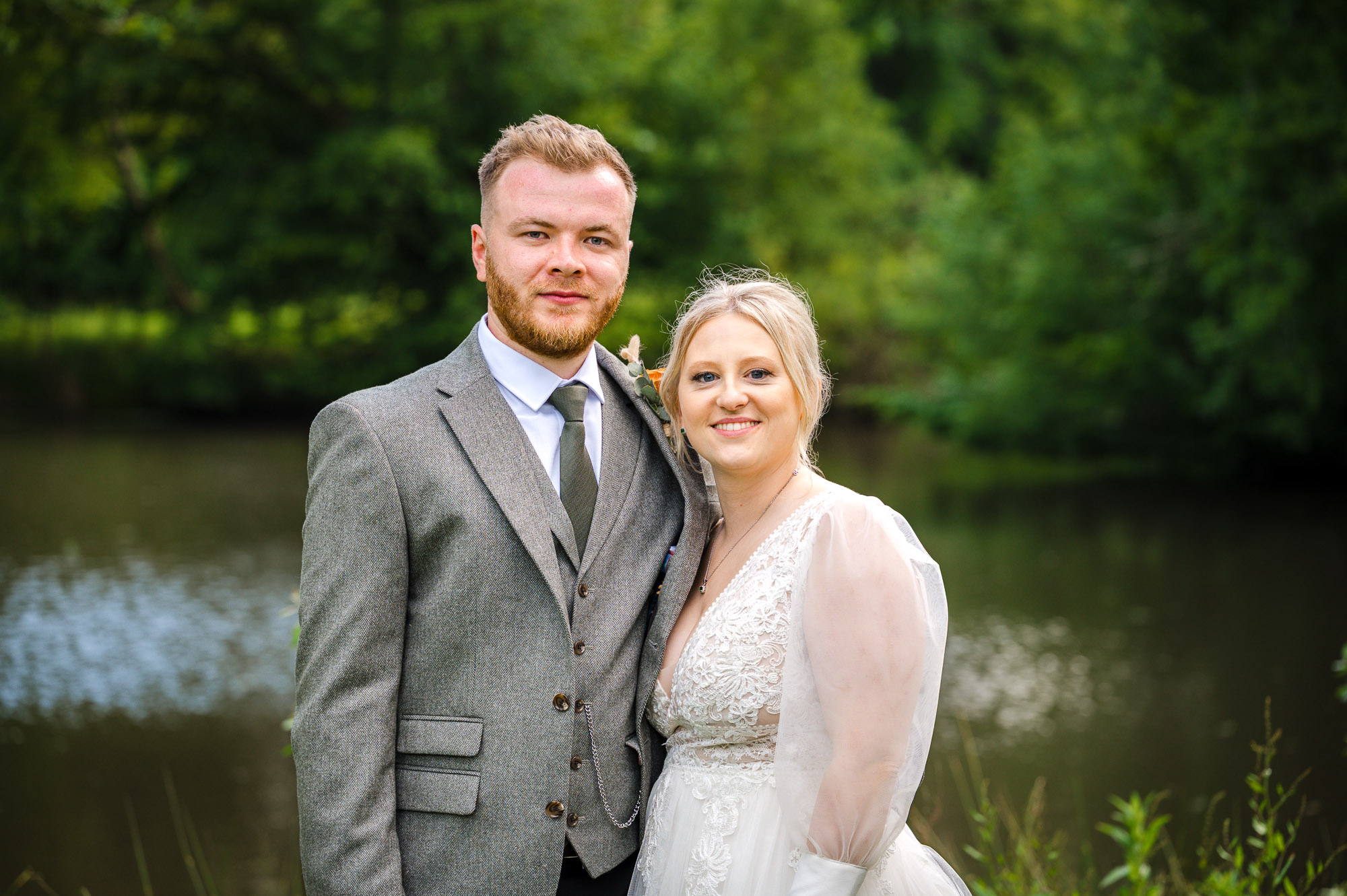 Bride and groom portraits by the lake at their wedding at Swallows Oast wedding venue, Ticehurst, East Sussex