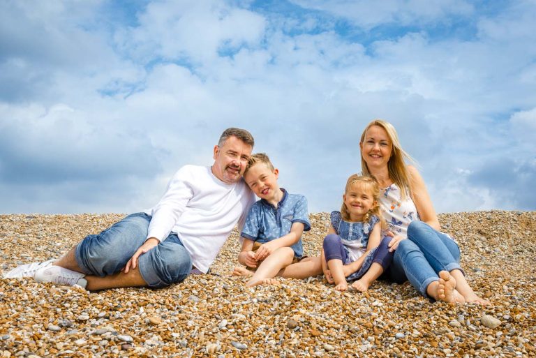 Camber Sands photo shoot, Sussex - family portrait while sitting on shingle beach