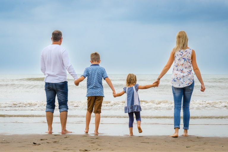 Camber Sands photo shoot, Sussex - family holding hands on beach and looking out to sea