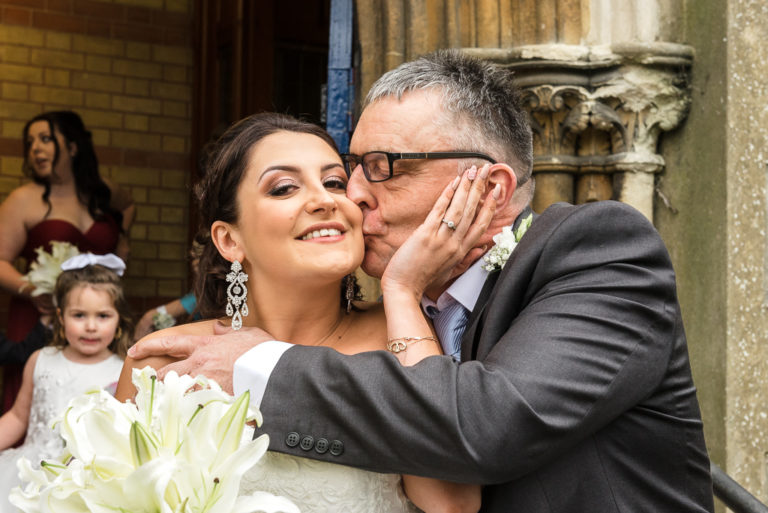 Fun shot of bride being kissed by her father before the ceremony | Sidcup Wedding of Becky & Hugo | Oakhouse Photography