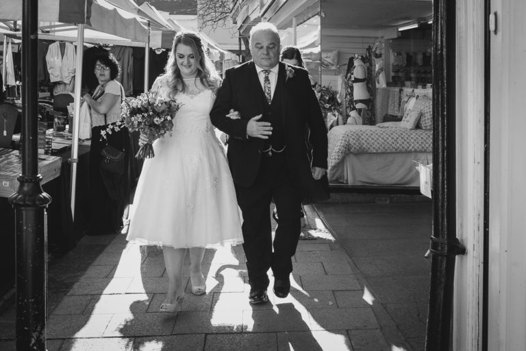 Bride and father walking through Faversham town centre on the way to the wedding ceremony | Oakhouse Photography