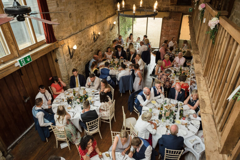 Wedding guests sitting down at the wedding breakfast at Swallows Oast wedding venue, Ticehurst, East Sussex | Oakhouse Photography