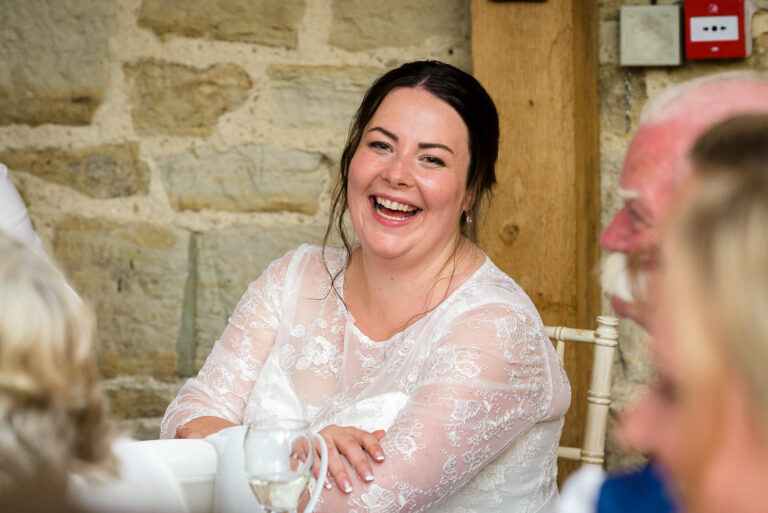 Bride laughing during speeches at Swallows Oast wedding venue, Ticehurst, East Sussex | Oakhouse Photography