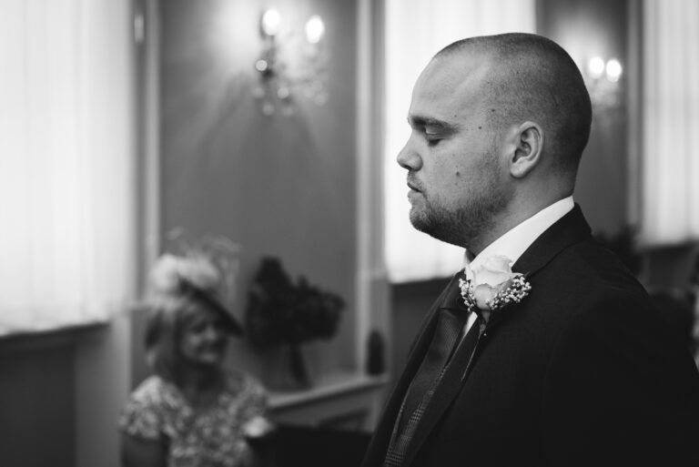Groom waiting with eyes closed for bride's arrival into the ceremony room at Chelsea Old Town Hall, King’s Road, London | Oakhouse Photography