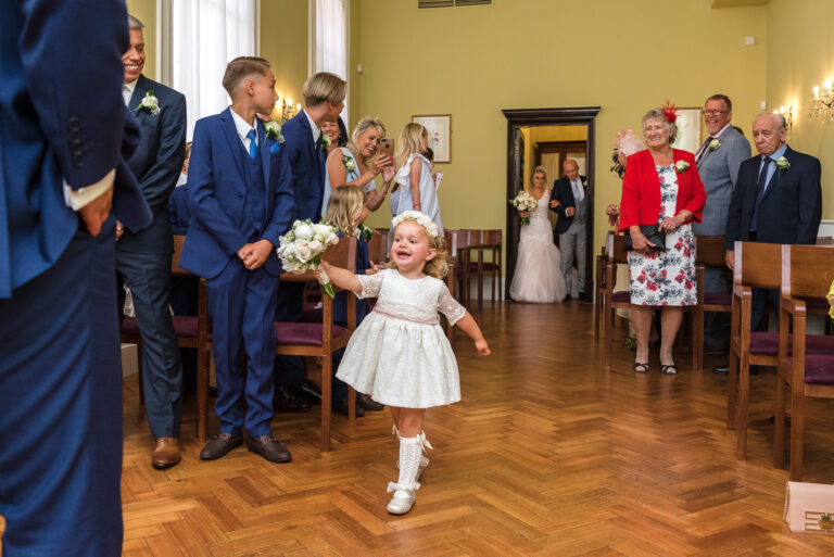 Flower girl running to her father at Chelsea Old Town Hall, King’s Road, London | Oakhouse Photography