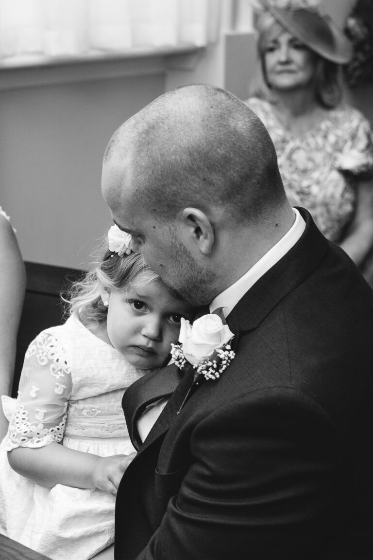 Groom holding his daughter during the wedding ceremony at Chelsea Old Town Hall, King’s Road, London | Oakhouse Photography