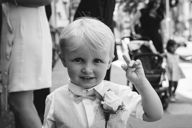Young boy waiting for the wedding to start outside Chelsea Old Town Hall, King’s Road, London | Oakhouse Photography