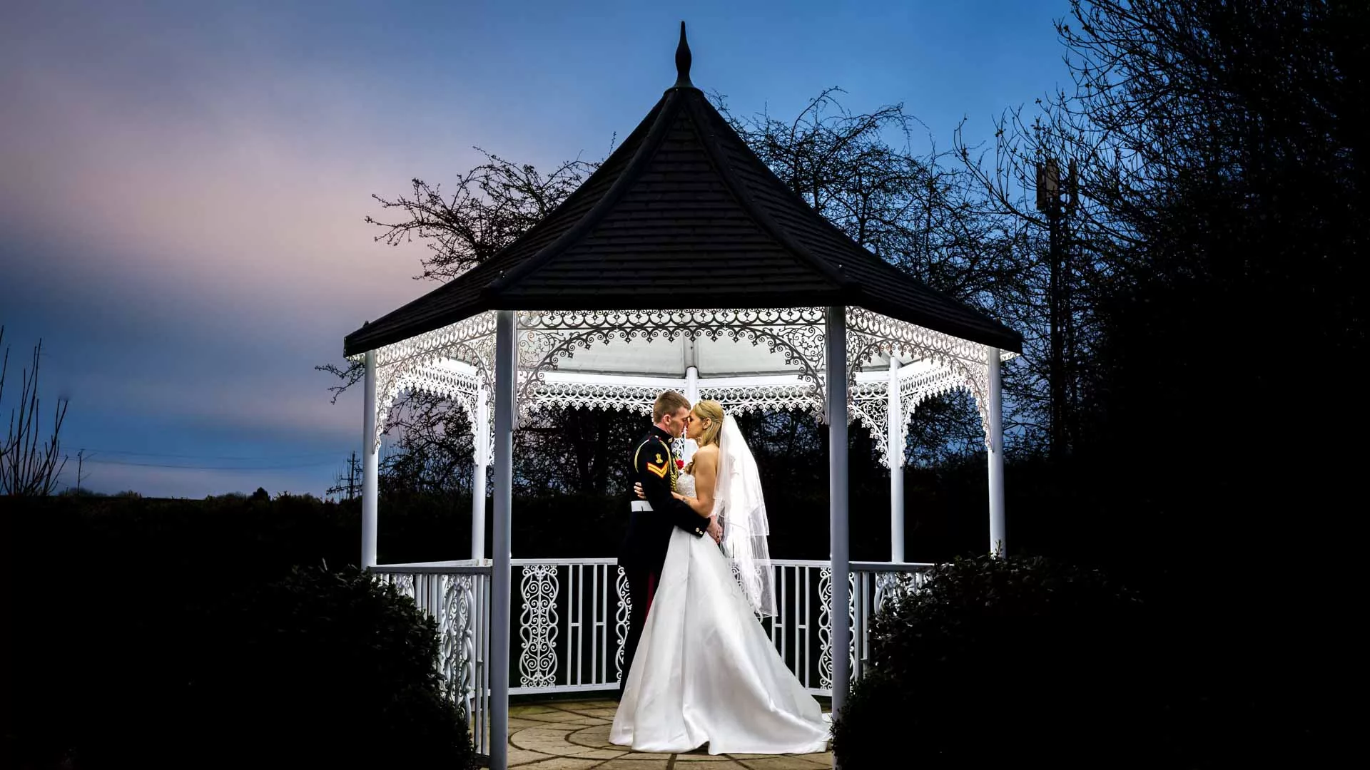 Military wedding with a wedding photograph of the bride and groom in a gazebo at The Orchard Suite, Maidstone