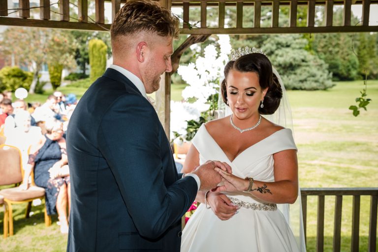 Bride and groom exchanging rings at Mercure Maidstone Great Danes Hotel wedding
