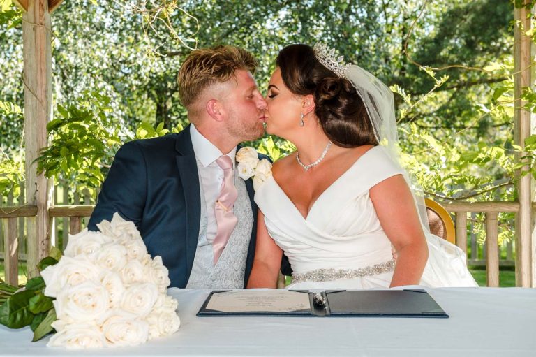Bride and groom kiss after signing the register in the gazebo at the Mercure Maidstone Great Danes Hotel wedding