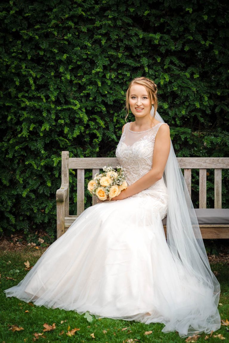 Portrait of bride on garden seat at Sprivers Mansion wedding venue, Kent