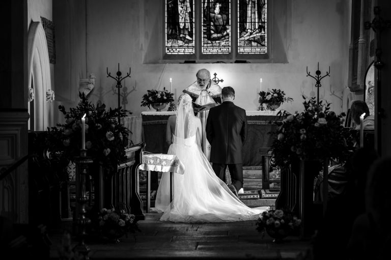 Bride and groom kneeling before the alter at their Hampshire wedding