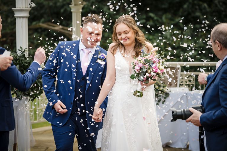 Bride and groom coming through confetti at their Hampshire wedding