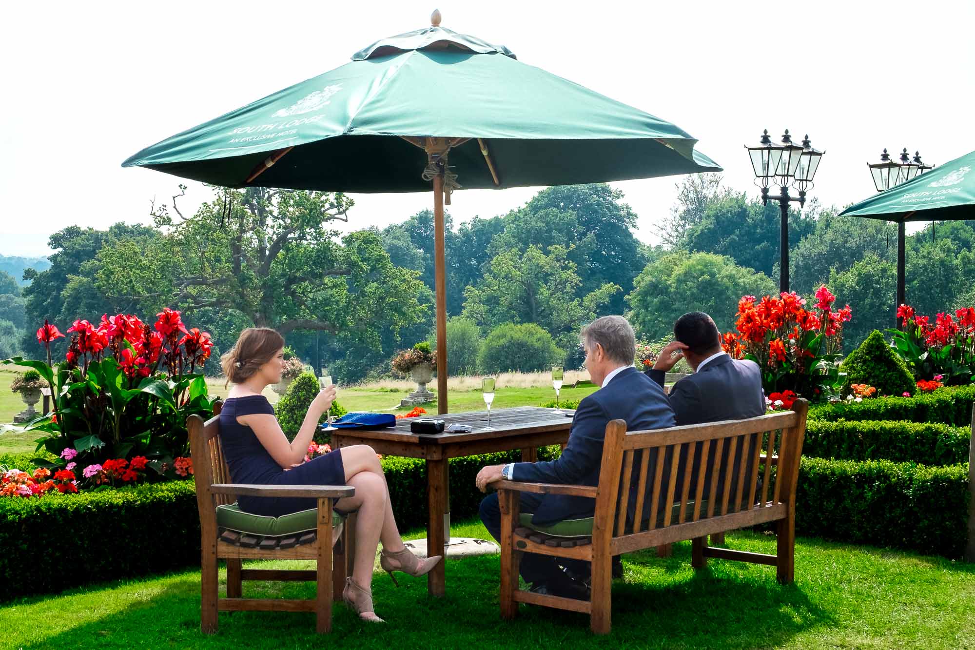 Guests drink on the terrace at a wedding at South Lodge Hotel, Horsham, East Sussex