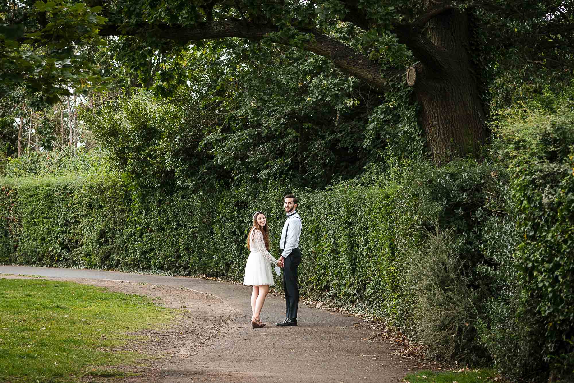 Newlyweds walking through the grounds of Danson Park following their wedding ceremony at Danson House, Bexleyheath, captured by Oakhouse Photography
