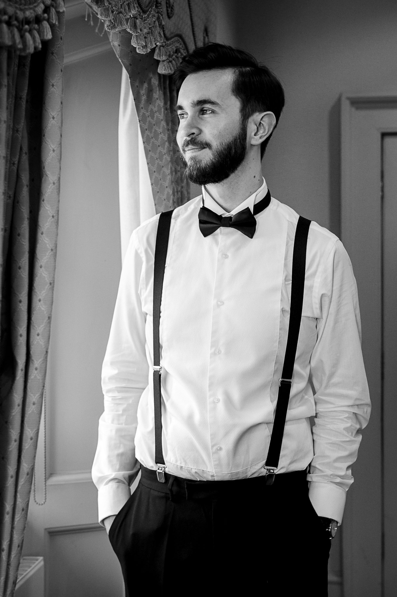 Groom looking wistfully out of the window before the wedding ceremony in The Johnson Room at Danson House, Danson Park, Bexleyheath, Kent