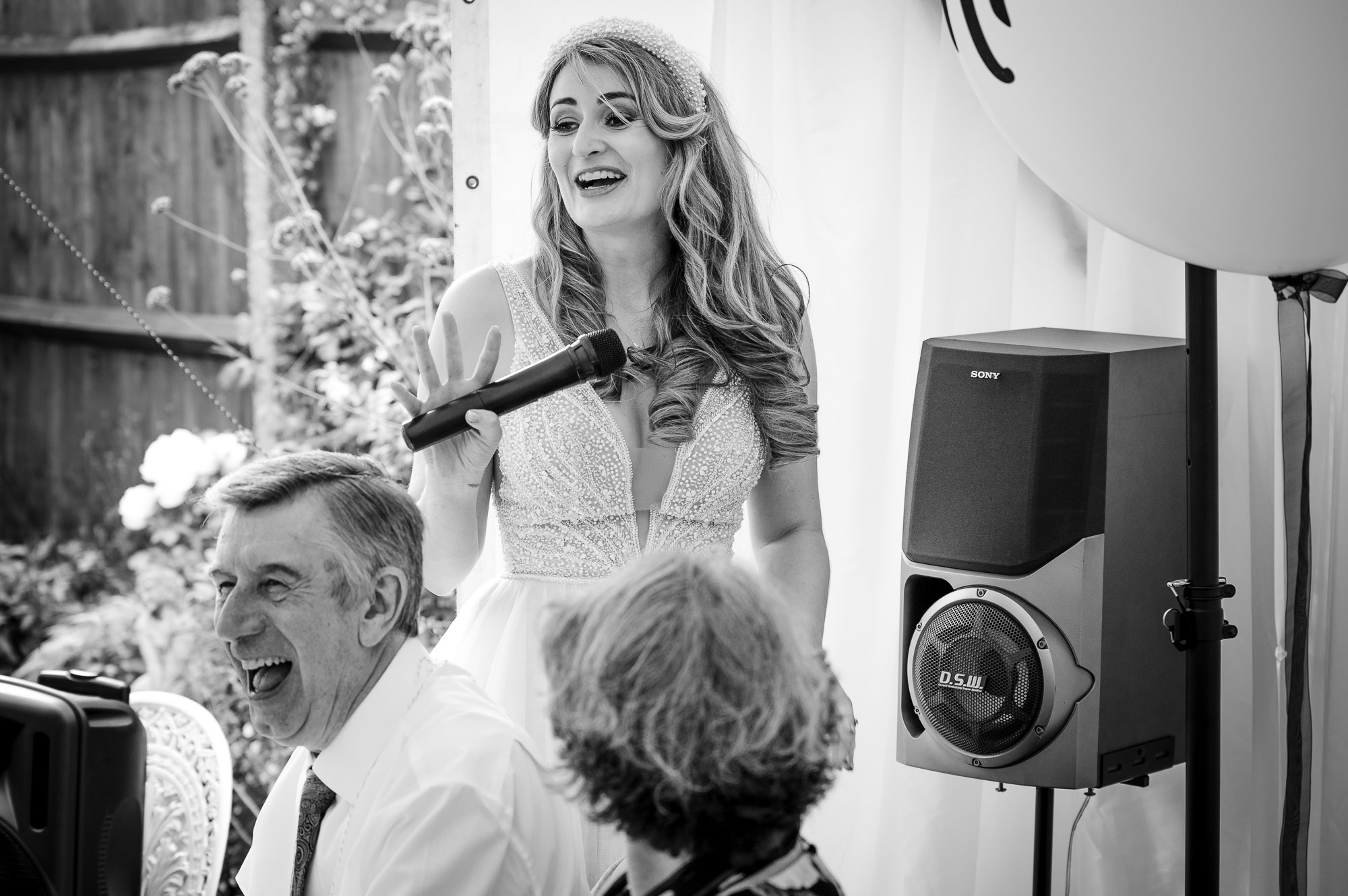 Bride carrying a microphone in preparation for the groom's speech at a London wedding