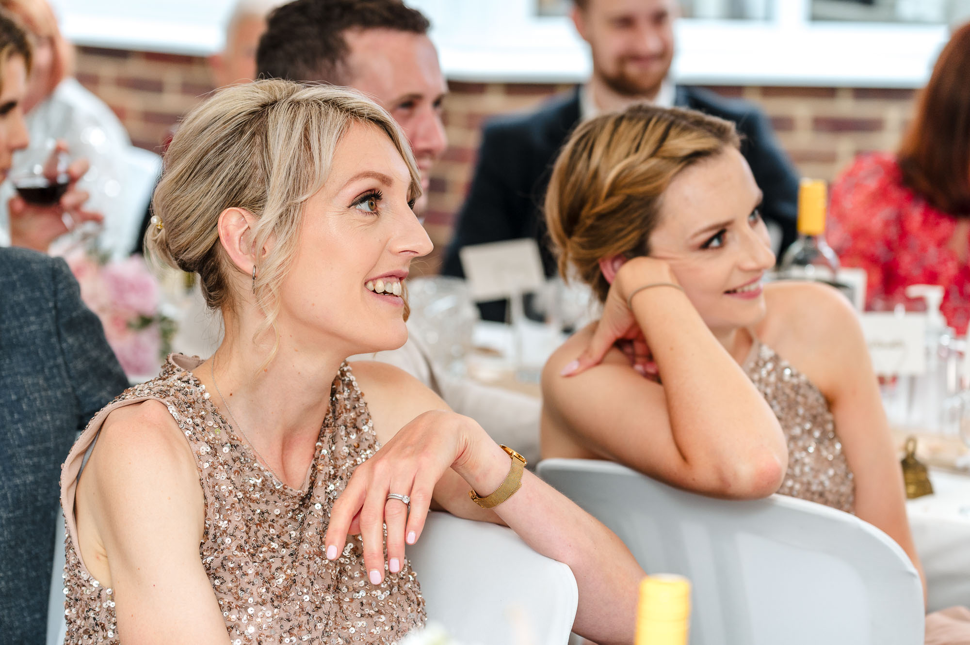 Documentary photograph of bridesmaids listening to the speeches at a Eltham, London wedding