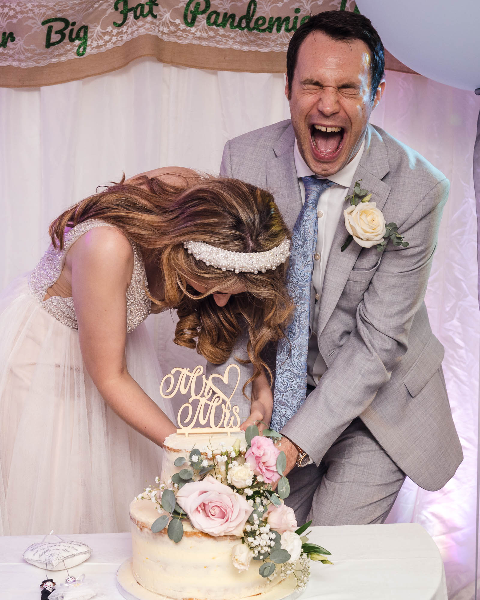 Bride and groom laughing when cutting the wedding cake at a London wedding