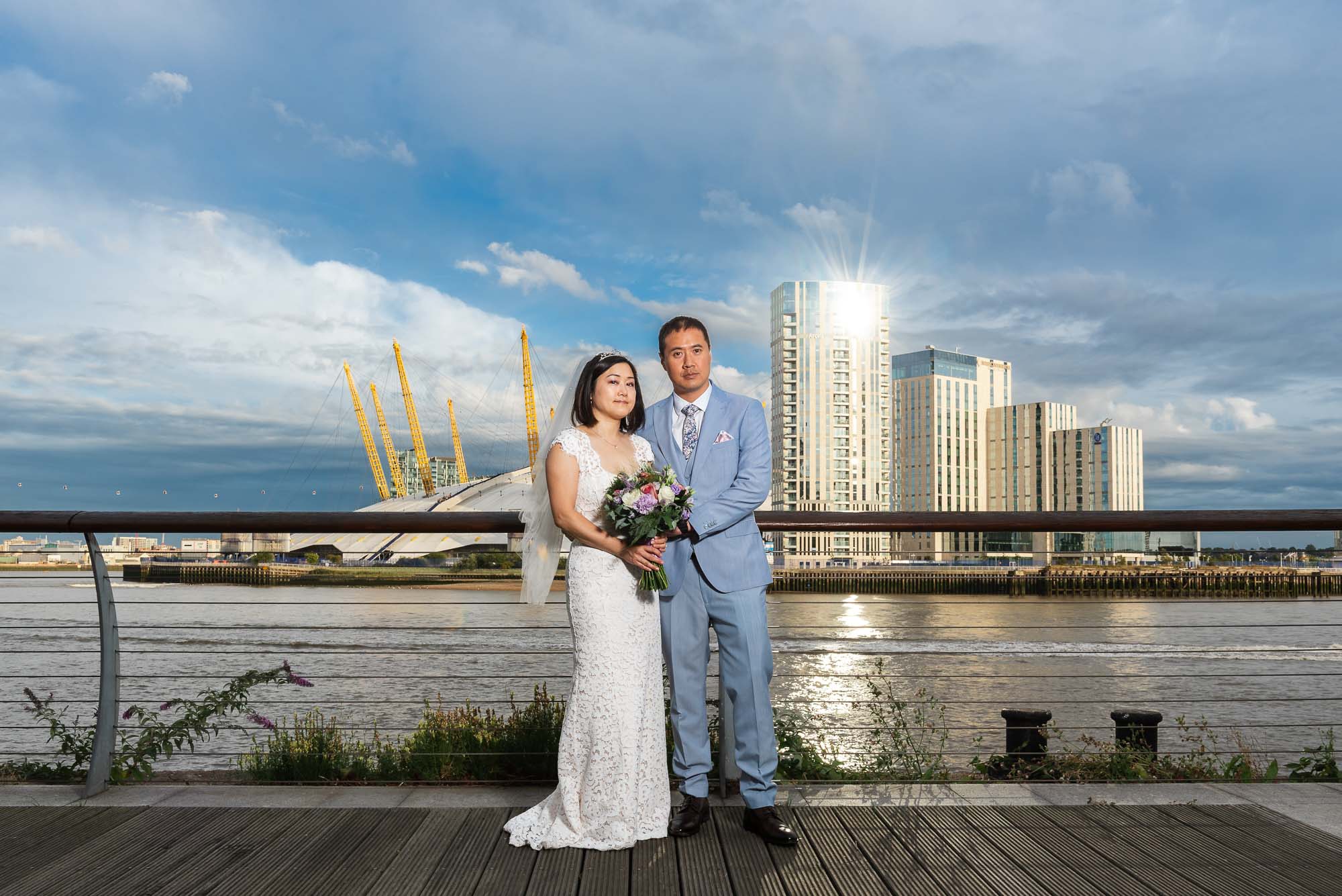 Bride and groom portrait with the O2 Greenwich on the River Thames as a backdrop for a London wedding