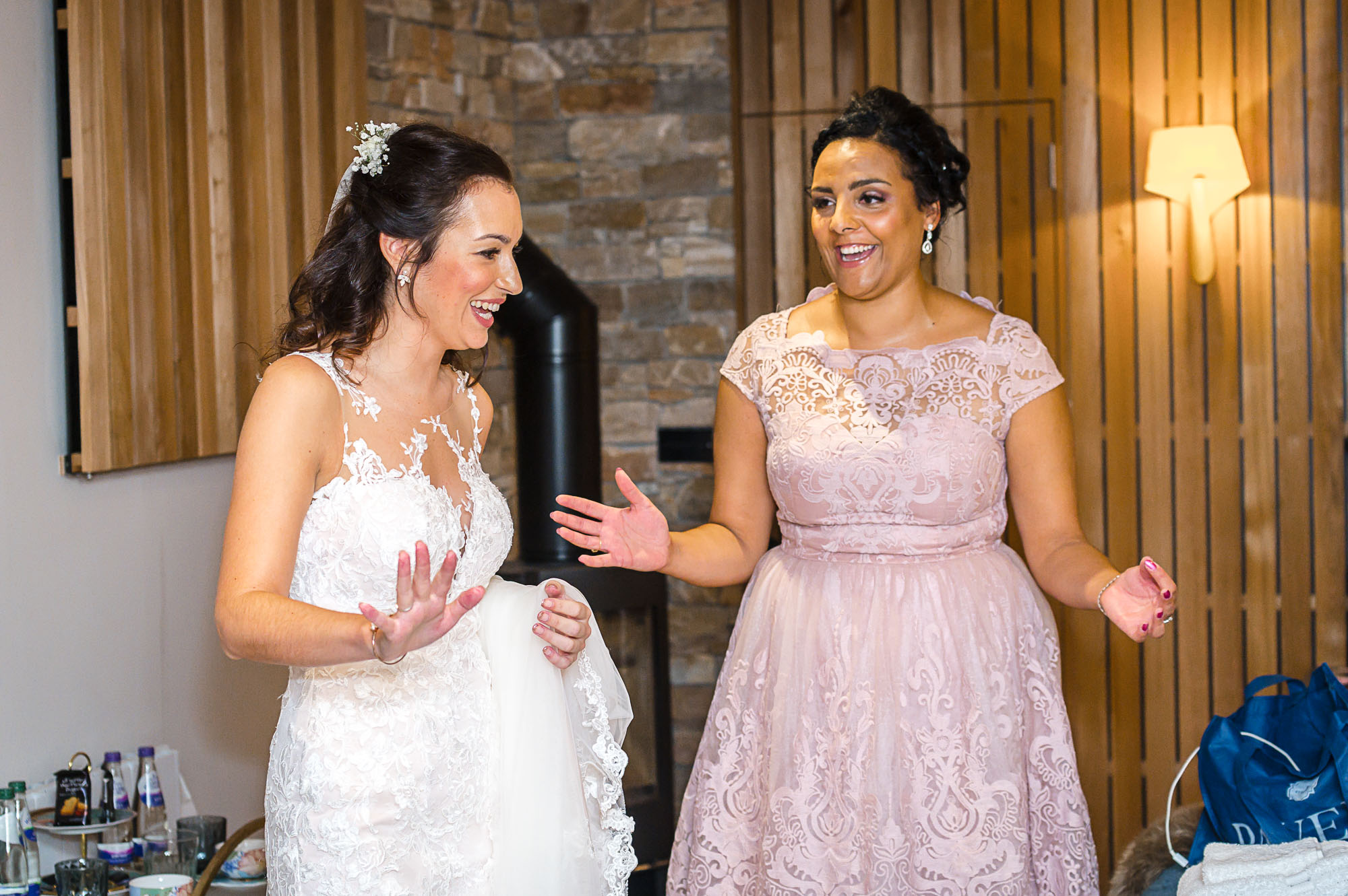 Bride and maid of honor sharing a laugh in The Bridal Suite at Swallows Oast wedding venue in Ticehurst, East Sussex