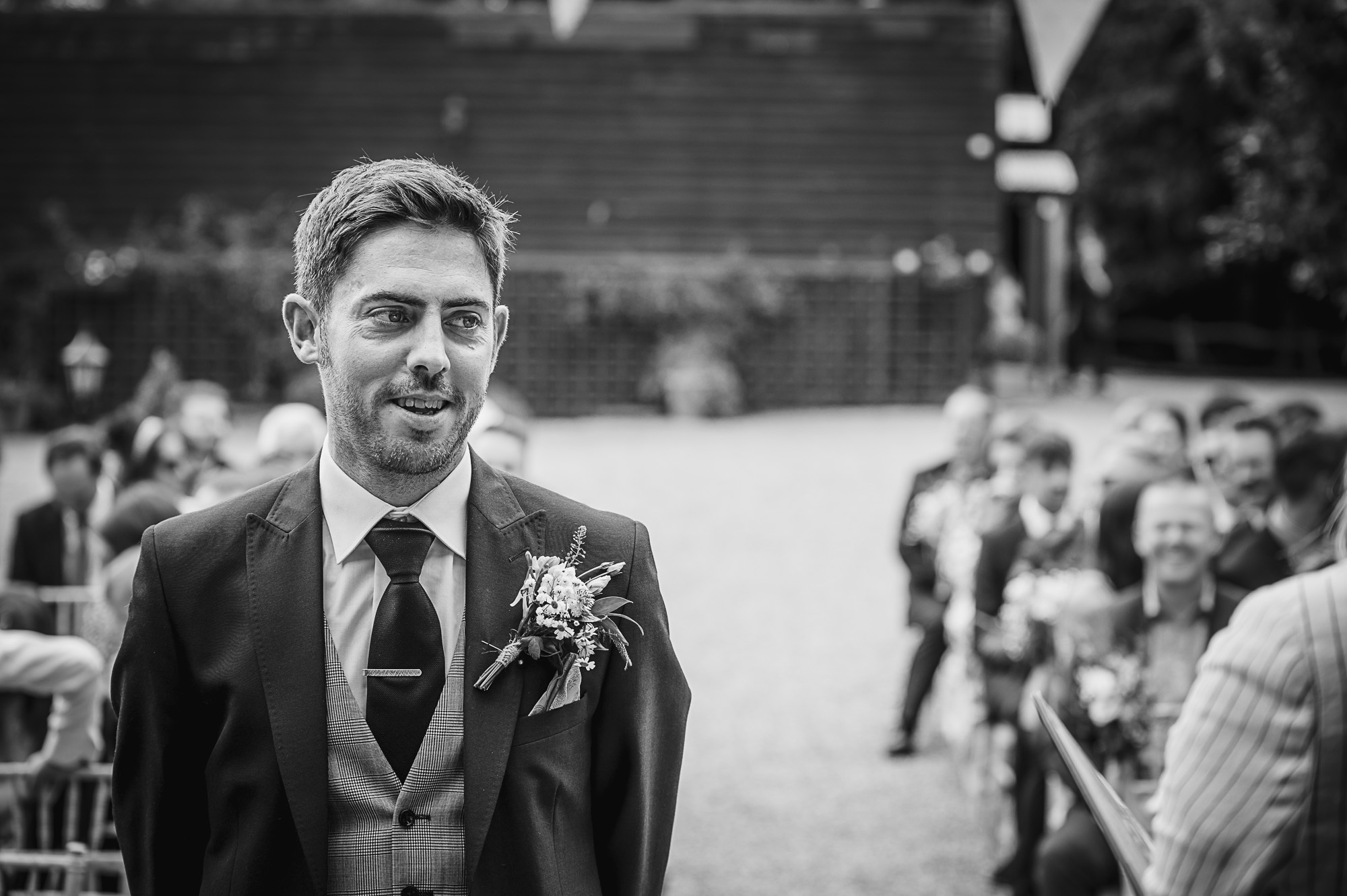Groom waiting for the bride's arrival for the outdoor wedding ceremony at The Pavilion at Swallows Oast wedding venue in Ticehurst, East Sussex