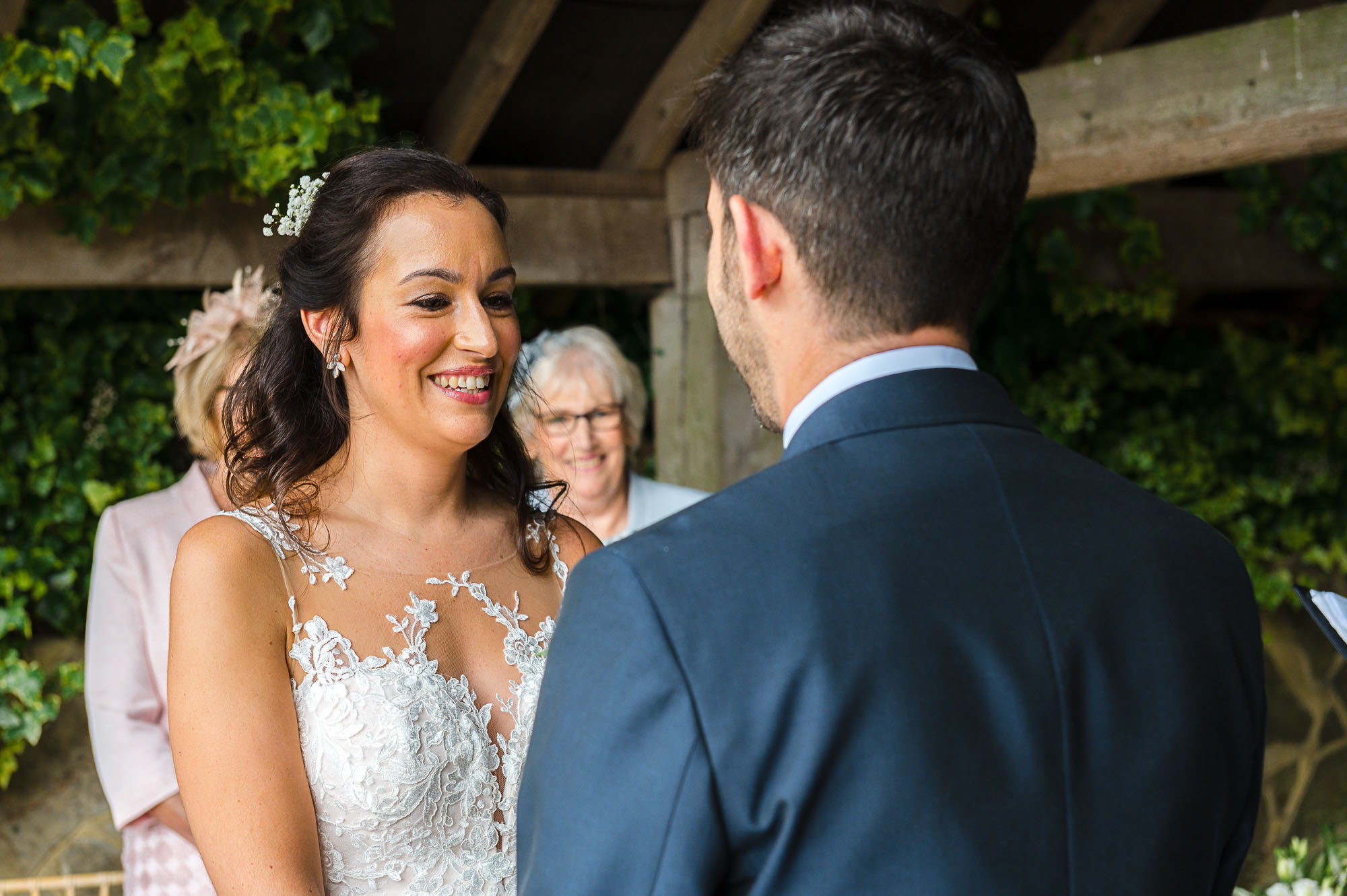 The exchanging of vows between the bride and groom under The Pavilion at their Swallows Oast wedding venue in Ticehurst, East Sussex