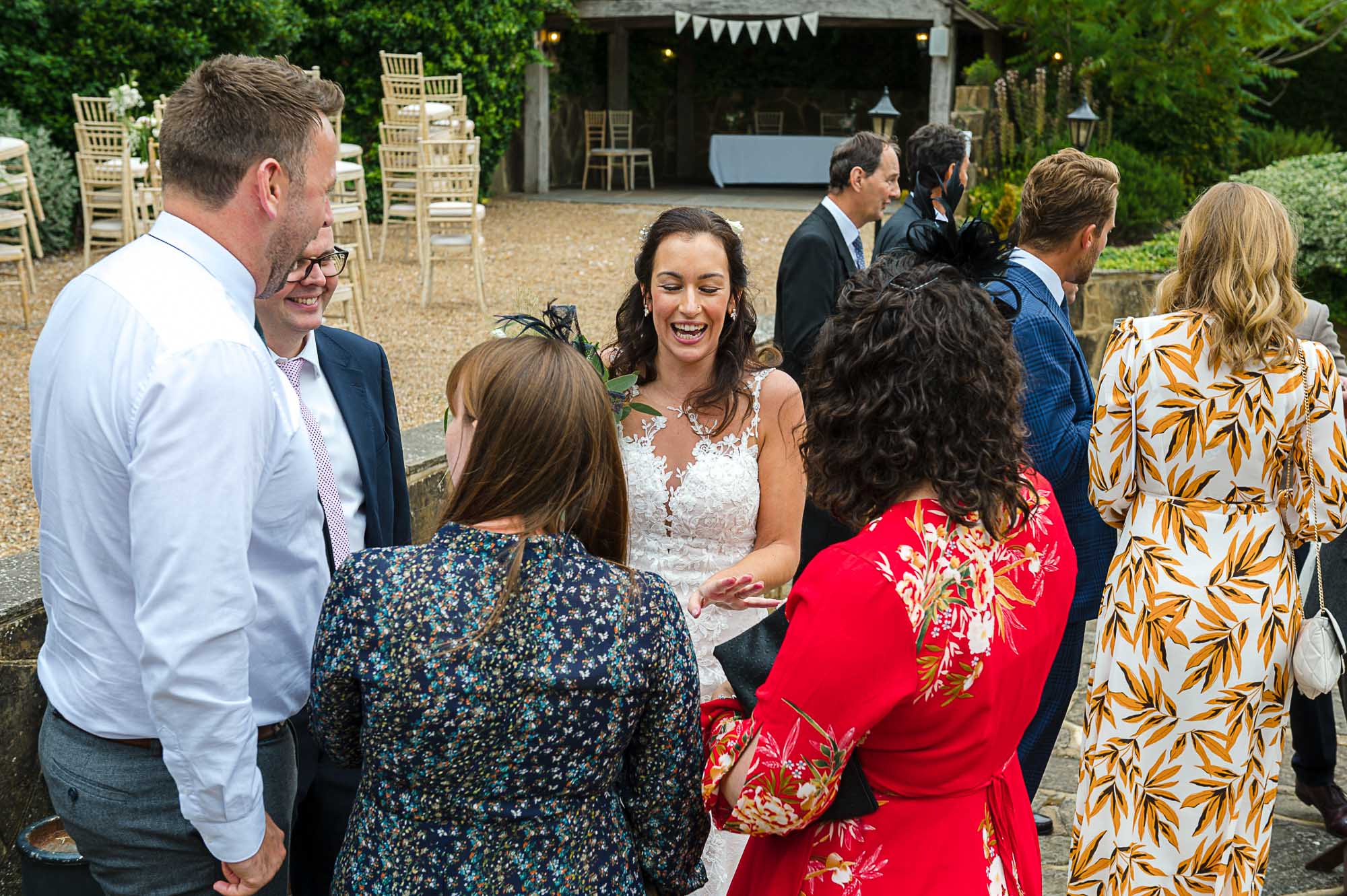 Candid documentary photograph of bride sharing a laugh with her guests at her Swallows Oast wedding venue in Ticehurst, East Sussex