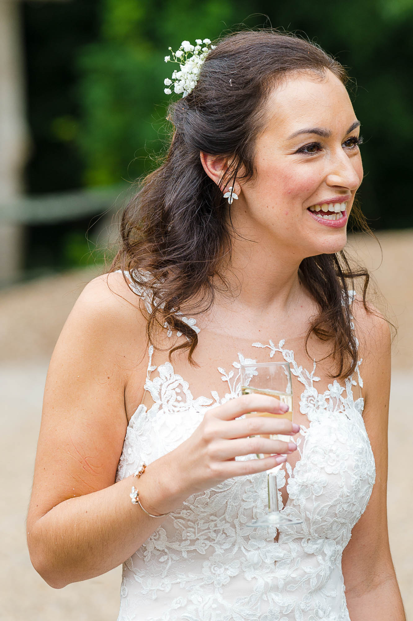 Candid documentary photograph of bride holding a glass of champagne at her Swallows Oast wedding venue in Ticehurst, East Sussex