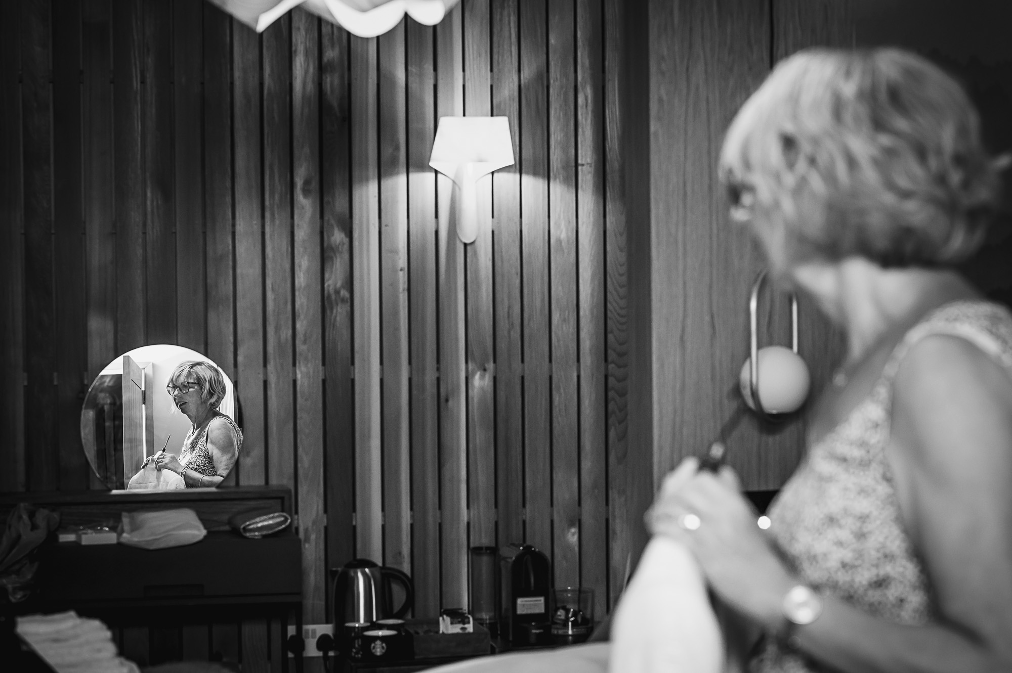 Portrait of groom's mother reflected in a mirror during bridal prep in The Bridal Suite at Swallows Oast wedding venue in Ticehurst, East Sussex | Oakhouse Photography