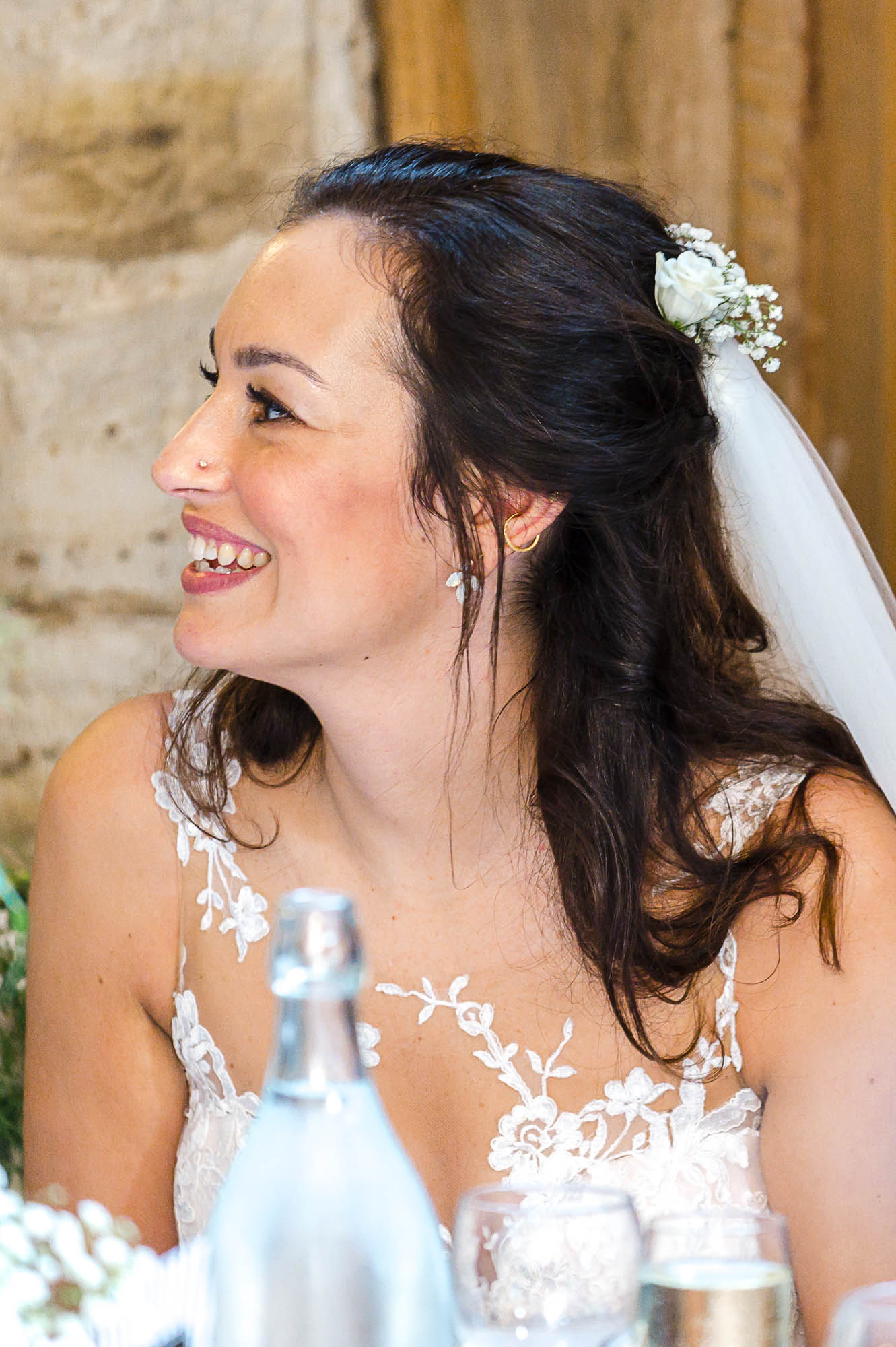 Bride listening to groom's speech during the reception at Swallows Oast wedding venue, Ticehurst, East Sussex