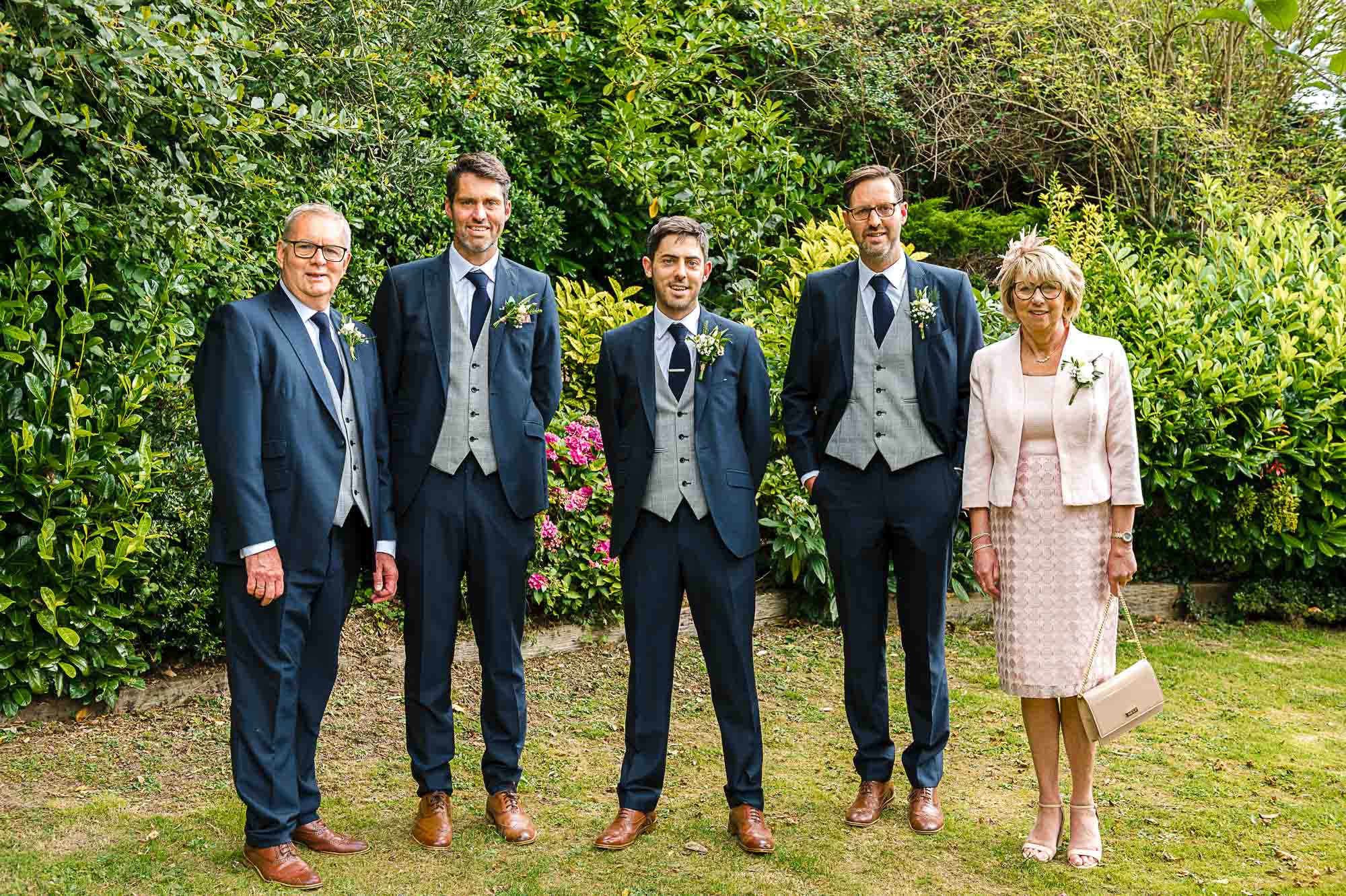 Portrait of groom, parents and brothers before the wedding ceremony at Swallows Oast wedding venue in Ticehurst, East Sussex