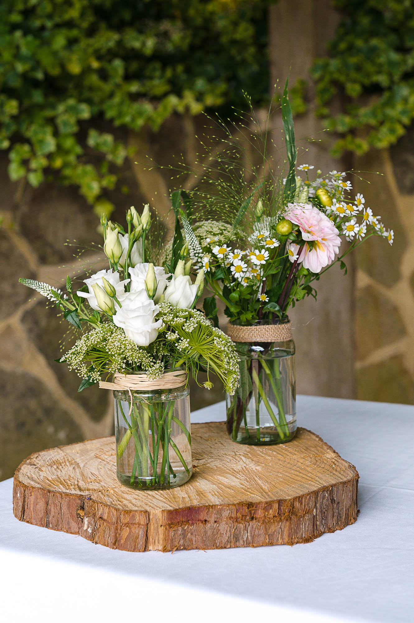 Detail photograph of flowers in jam jars with hessium finish ahead of the wedding at Swallows Oast wedding