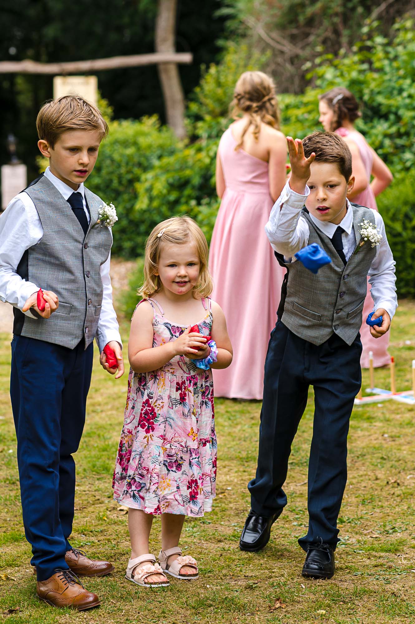 Children playing lawn games and throwing bean bags before the wedding ceremony at Swallows Oast wedding venue in Ticehurst, East Sussex