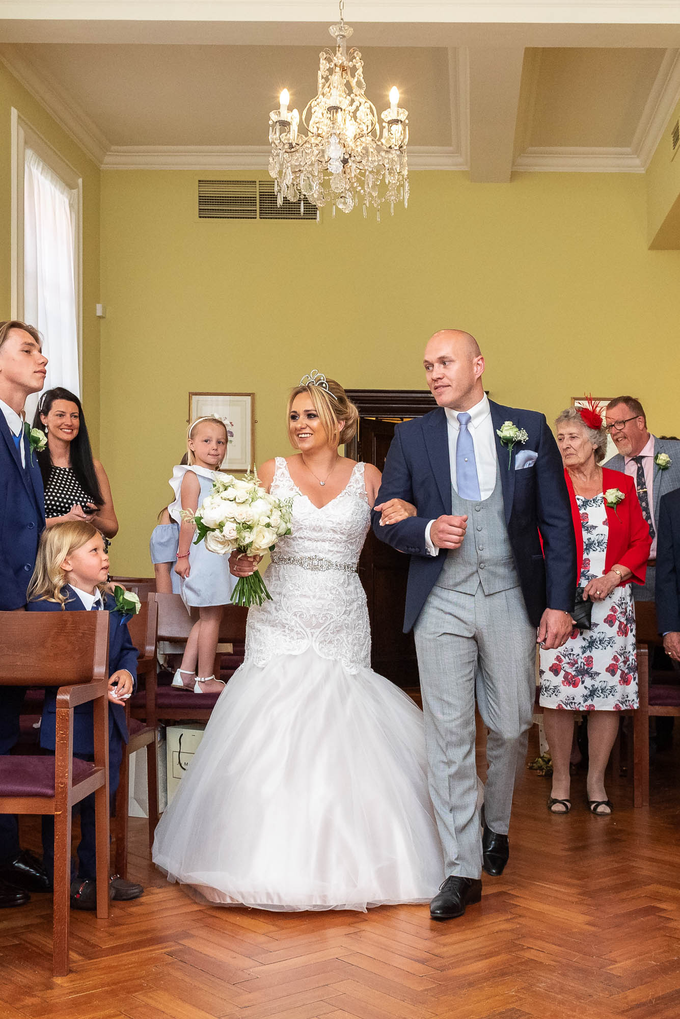 Bride and brother entering the ceremony room at Chelsea Old Town Hall wedding