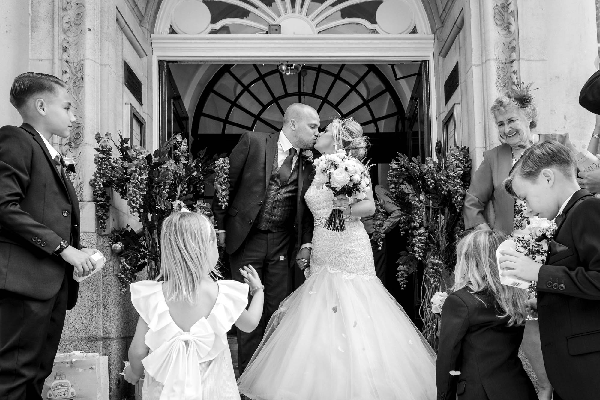 Bride and groom kissing on the steps of Chelsea Old Town Hall registry office