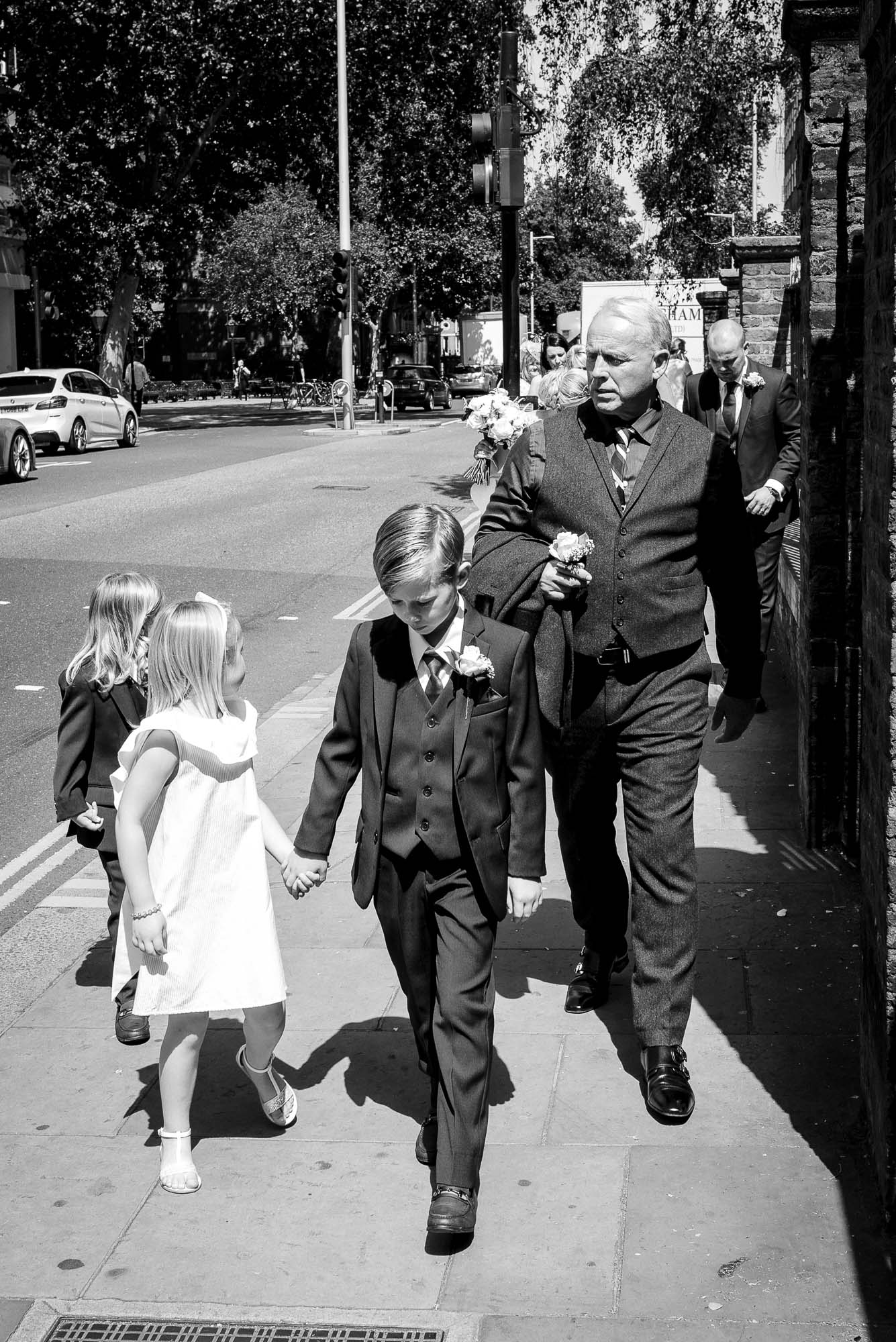 Wedding guests on walk down the King's Road to Bluebird Chelsea wedding reception