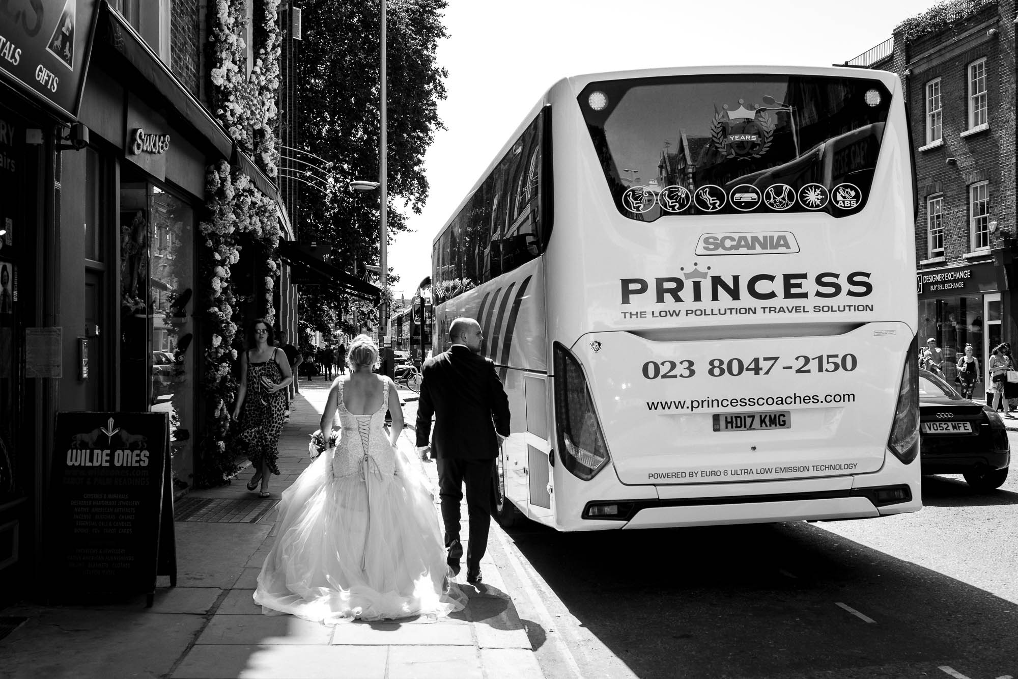 Bride and groom on walk down the King's Road to Bluebird Chelsea wedding reception