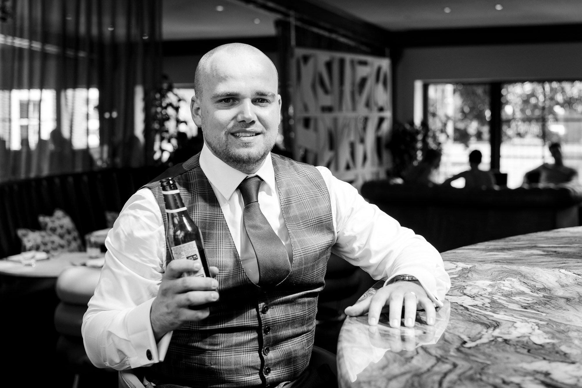 Portrait of groom with bottle of beer at Bluebird Chelsea