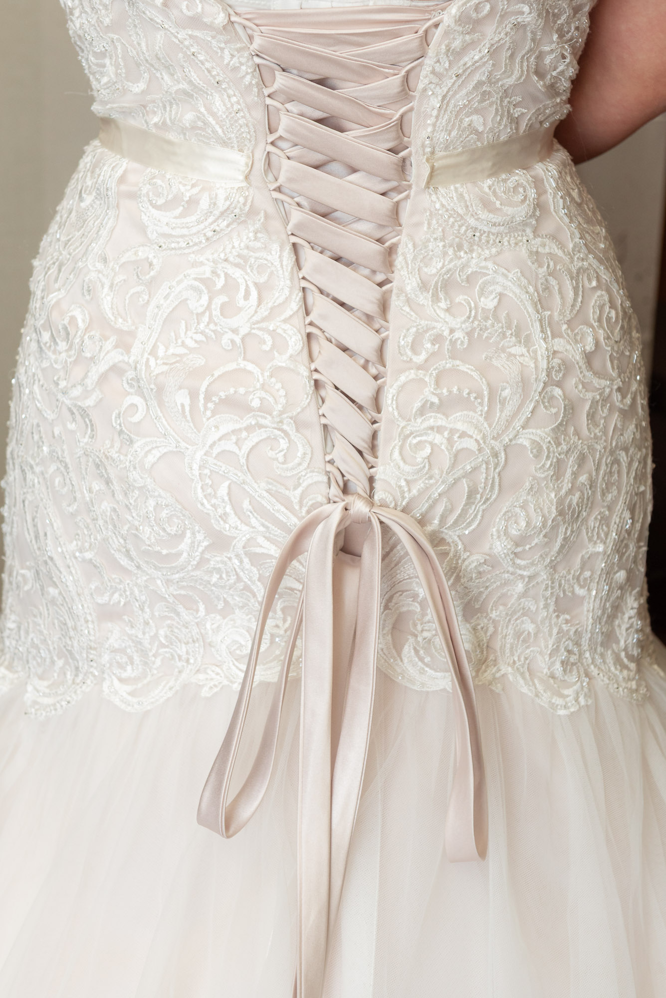Weding inspiration of a close-up of rear of bride's wedding dress showing intricate lace detailing at Chelsea Harbour Hotel, London
