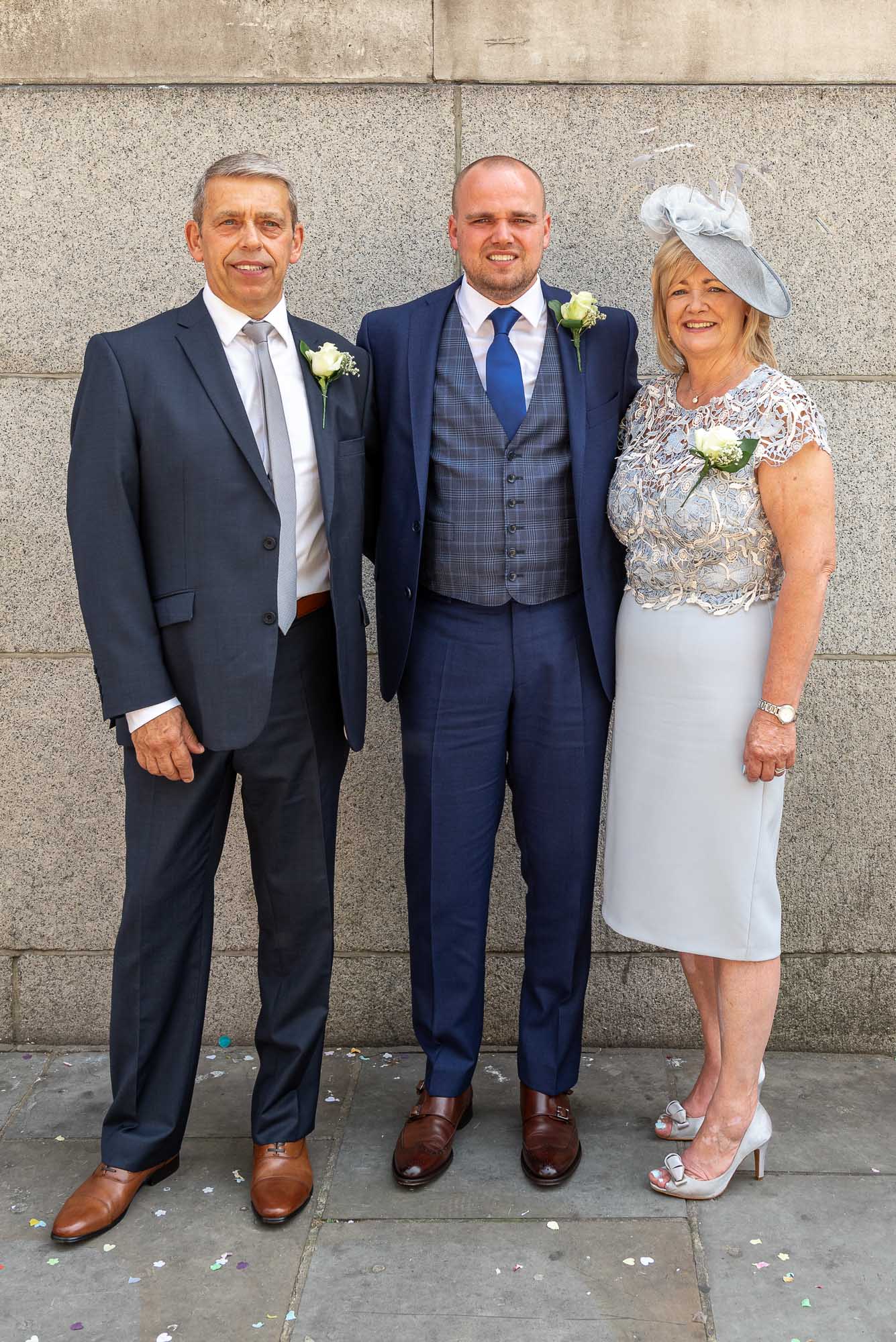 Portrait of groom and parents outside at his Chelsea Old Town Hall wedding