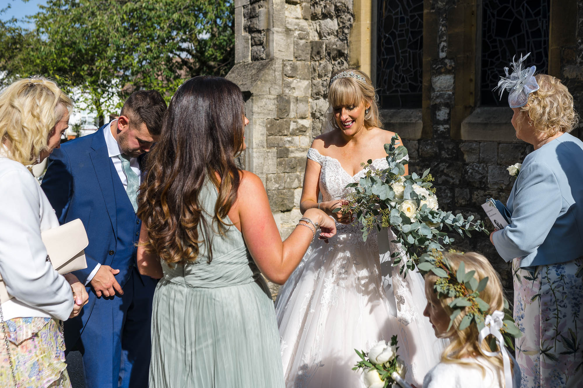 Bride chatting to guests in front of St John the Evangelist Church, Bexley, Kent