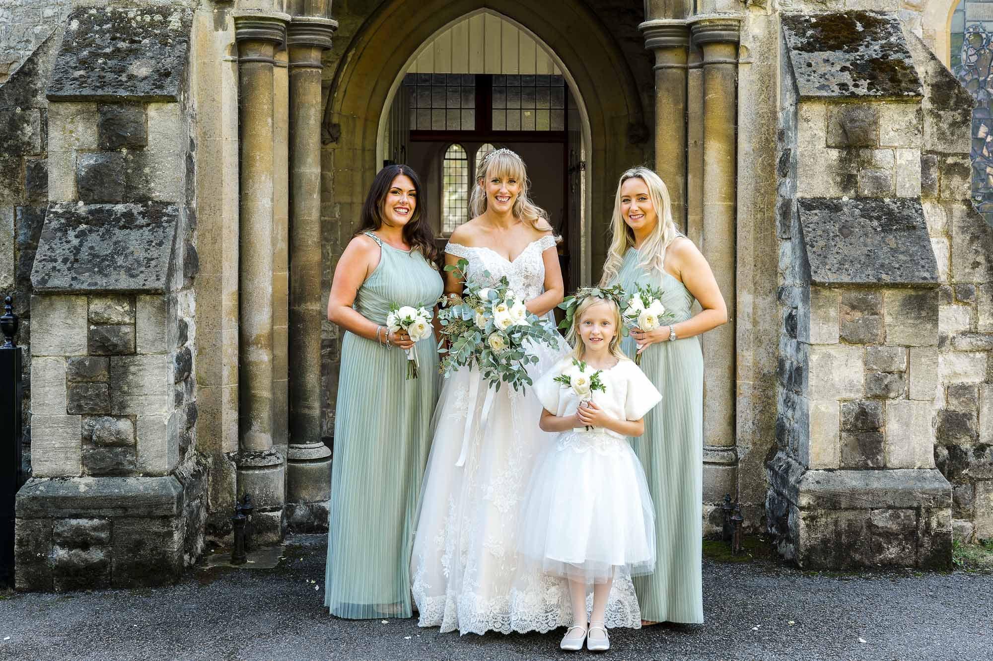 Bride and bridesmaids portrait in front of St John the Evangelist Church, Bexley, Kent