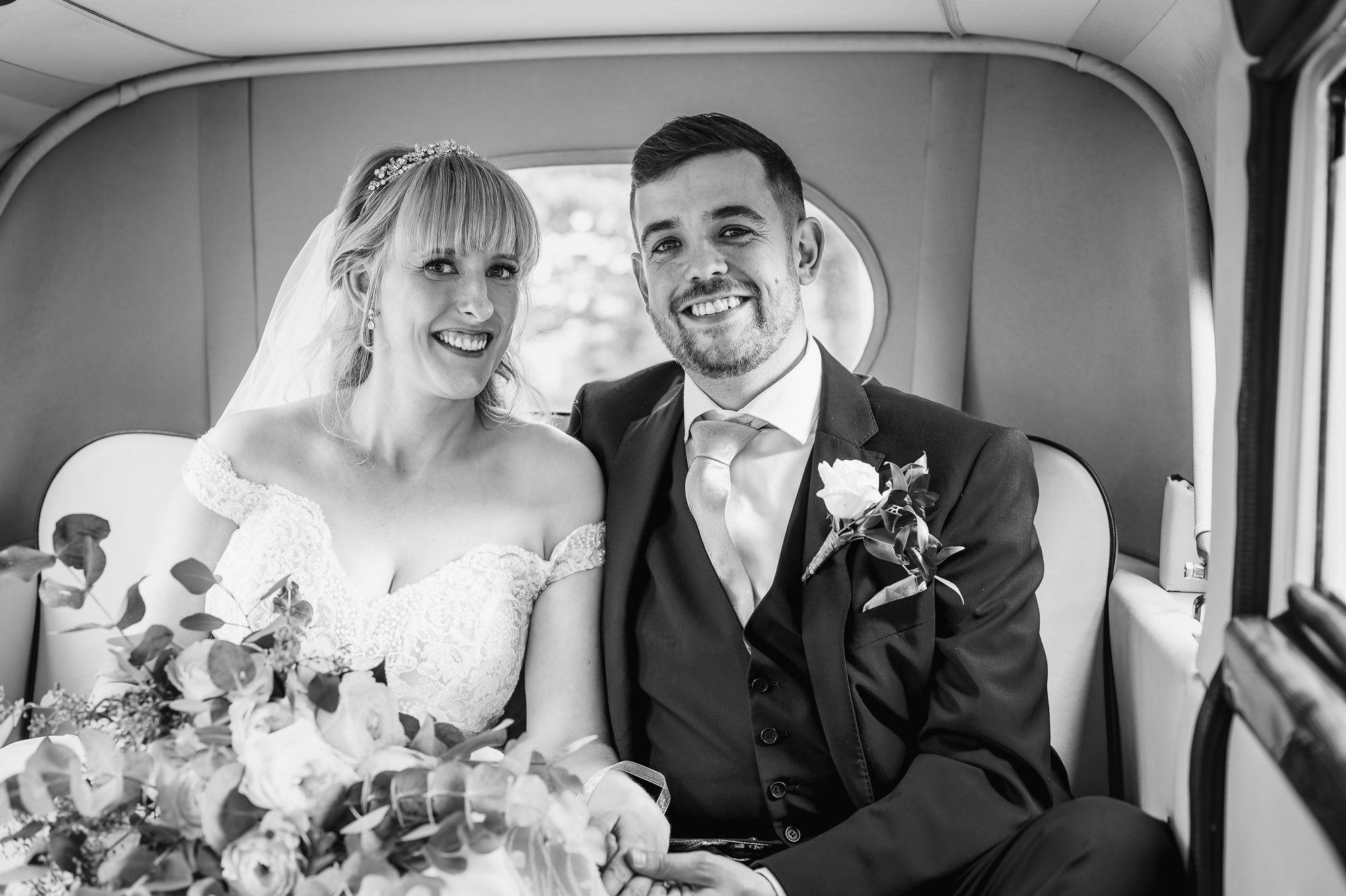 Bride and groom in the back of the vintage wedding car at St Johns the Evangelist Church, Bexley, Kent