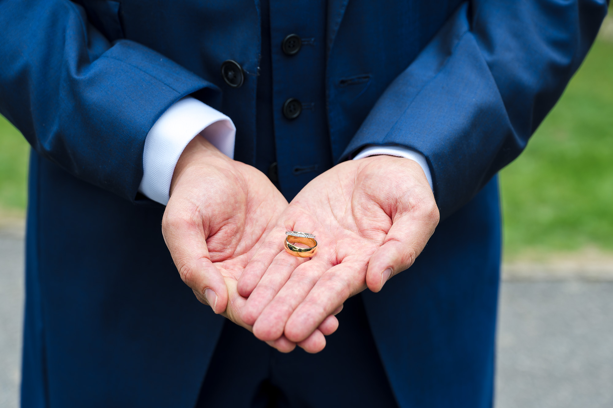 Groom holding wedding rings